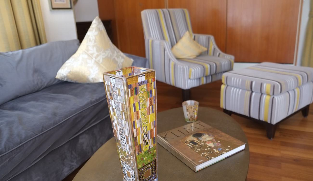 Gemütlicher Fernsehsessel im Wohnzimmer Wohnzimmer Ferienwohnung Klimt ausgestattet mit Fernsehsessel und gemütlicher Couch mit schönen Deko-Kissen